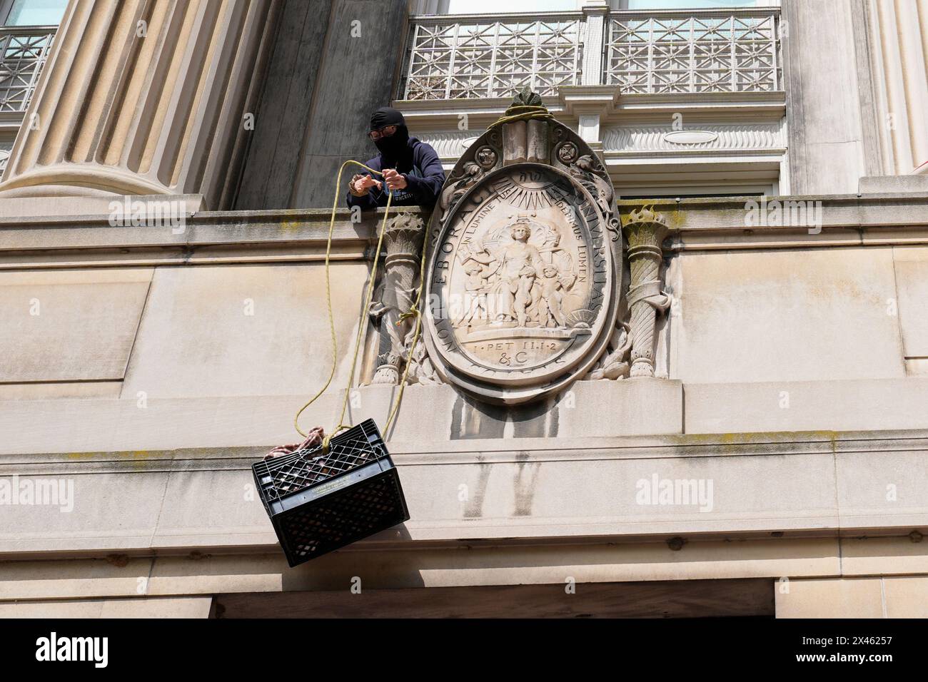 New York, USA. 30th Apr, 2024. A student protester pulls up a crate filled with foot and supplies from a balcony of Hamilton Hall on the campus of Columbia University, Tuesday, April 30, 2024, in New York. Early Tuesday, dozens of protesters took over Hamilton Hall, locking arms and carrying furniture and metal barricades to the building. Columbia responded by restricting access to campus. (Photo by Mary Altaffer/Pool/Sipa USA) Credit: Sipa USA/Alamy Live News Stock Photo