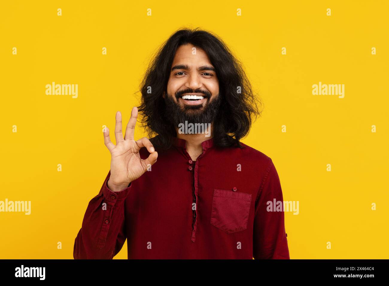 Smiling Bearded Man in Red Shirt Making OK Gesture Stock Photo