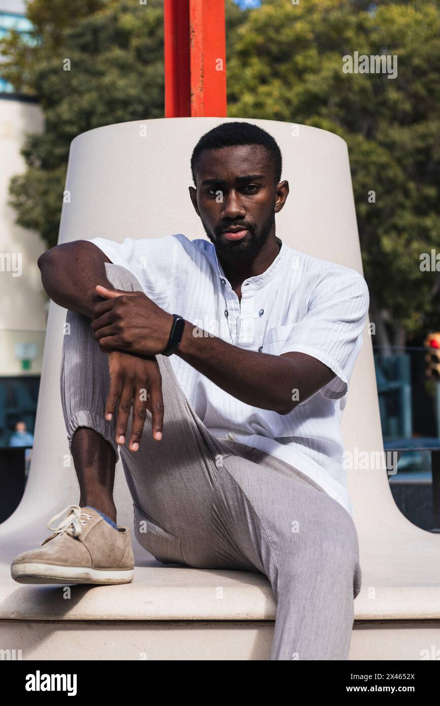 Confident African American male in summer outfit relaxing on concrete bench in city on sunny day Stock Photo Alamy