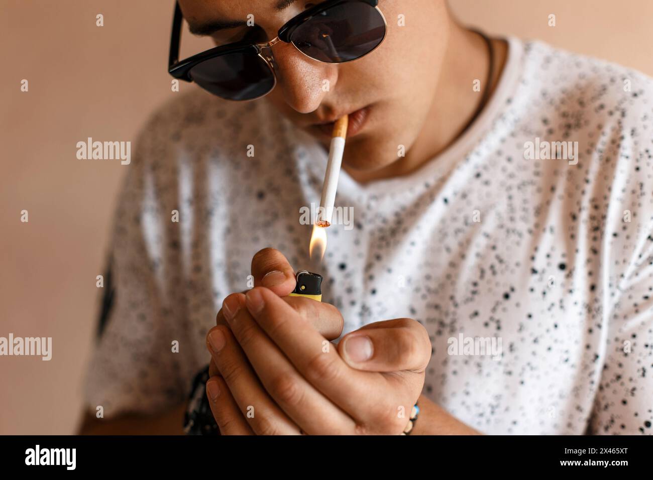 Young Man Lights A Cigarette. Stock Photo