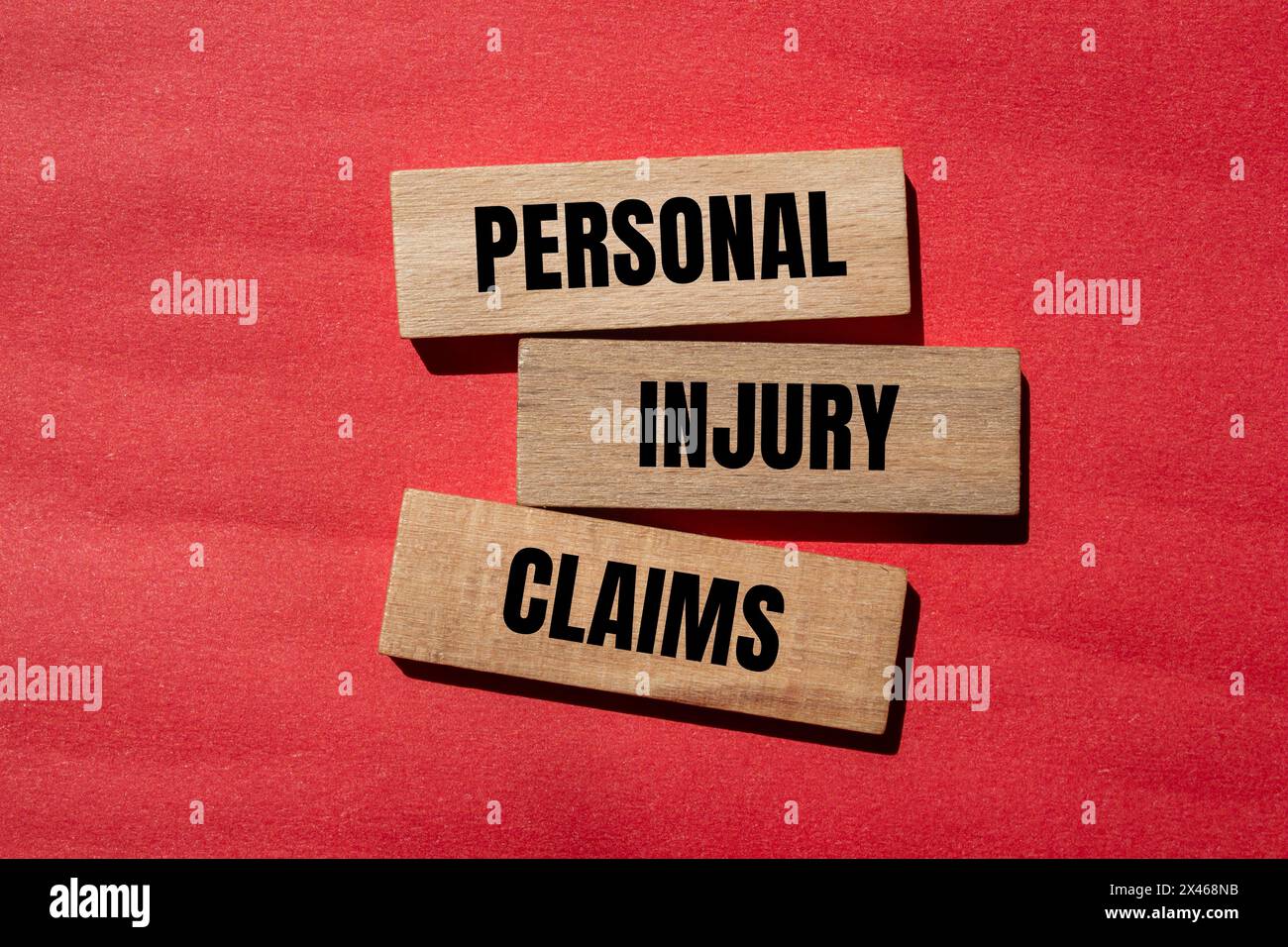Personal injury claims written on wooden blocks with red background. Conceptual personal injury claims symbol. Copy space. Stock Photo