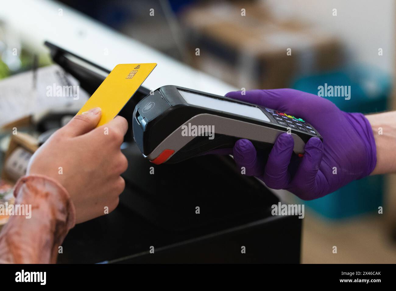 Unrecognizable crop female with plastic card making payment on POS terminal in cafe Stock Photo