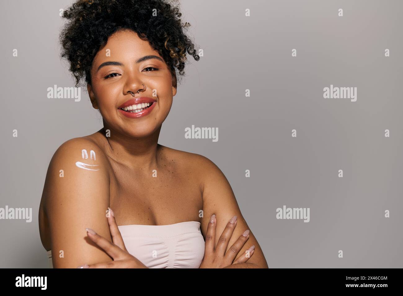 A beautiful young African American woman with curly hair poses ...