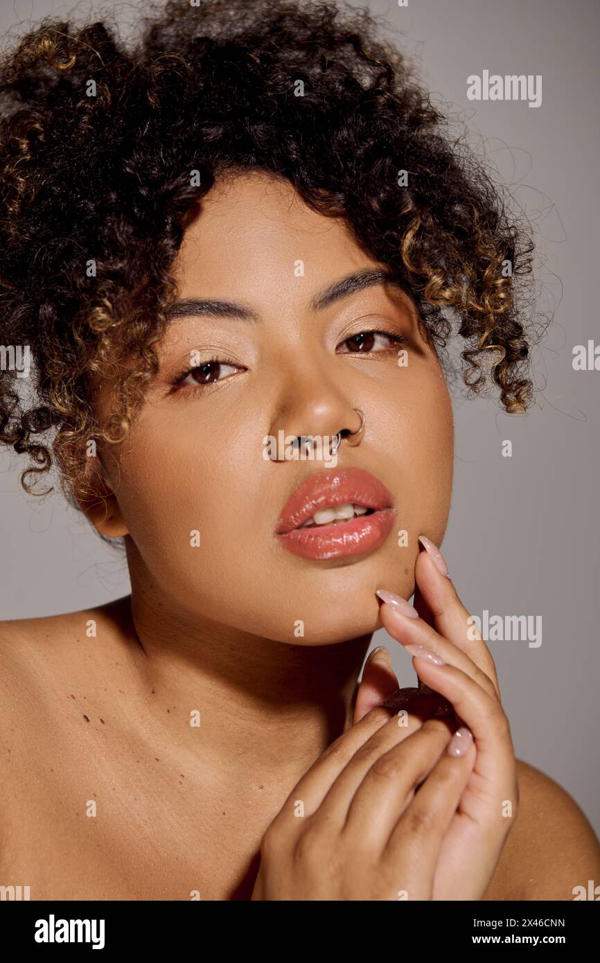 A beautiful young African American woman with curly hair is striking a ...