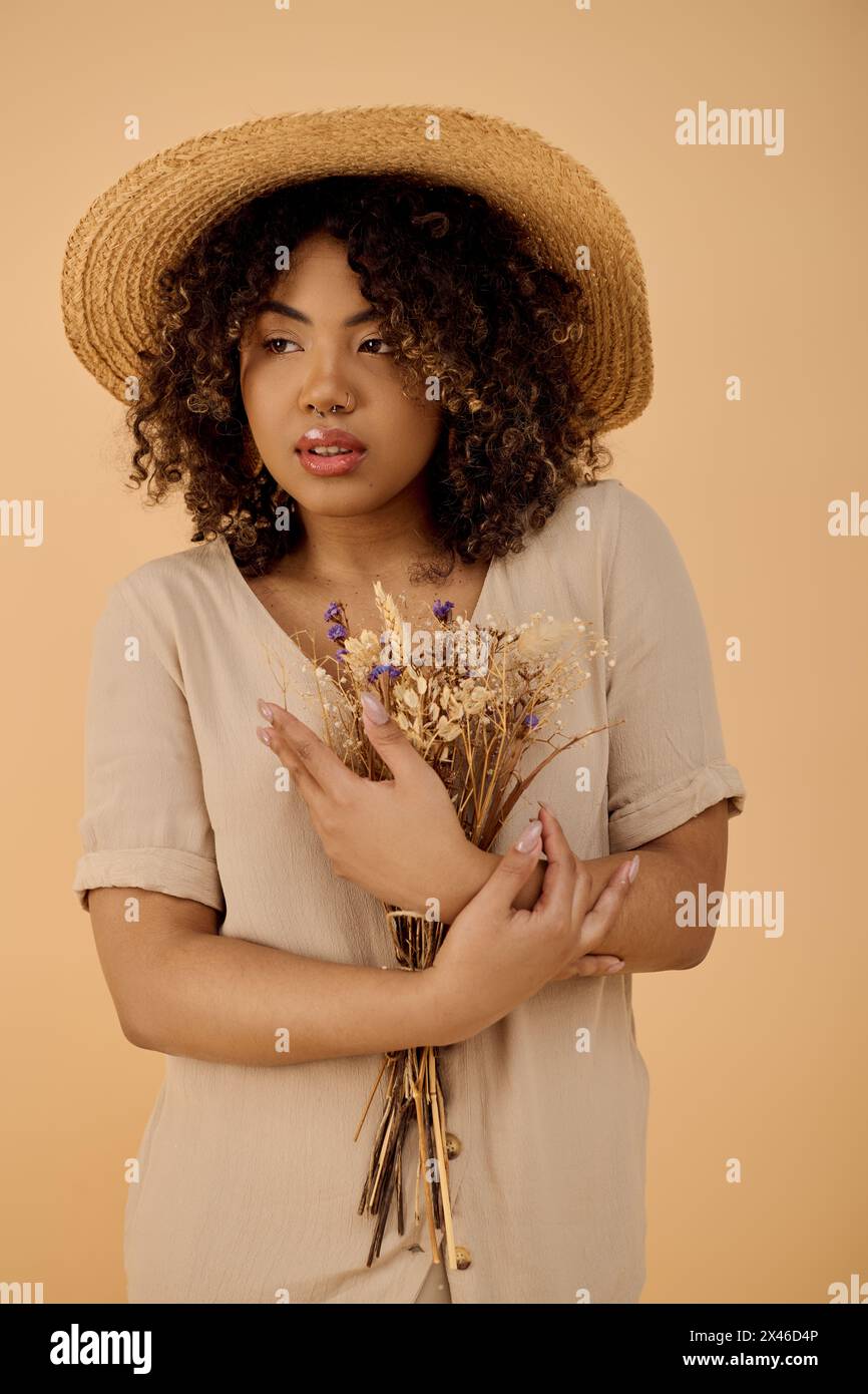 Young African American woman with curly hair and summer dress holding a ...