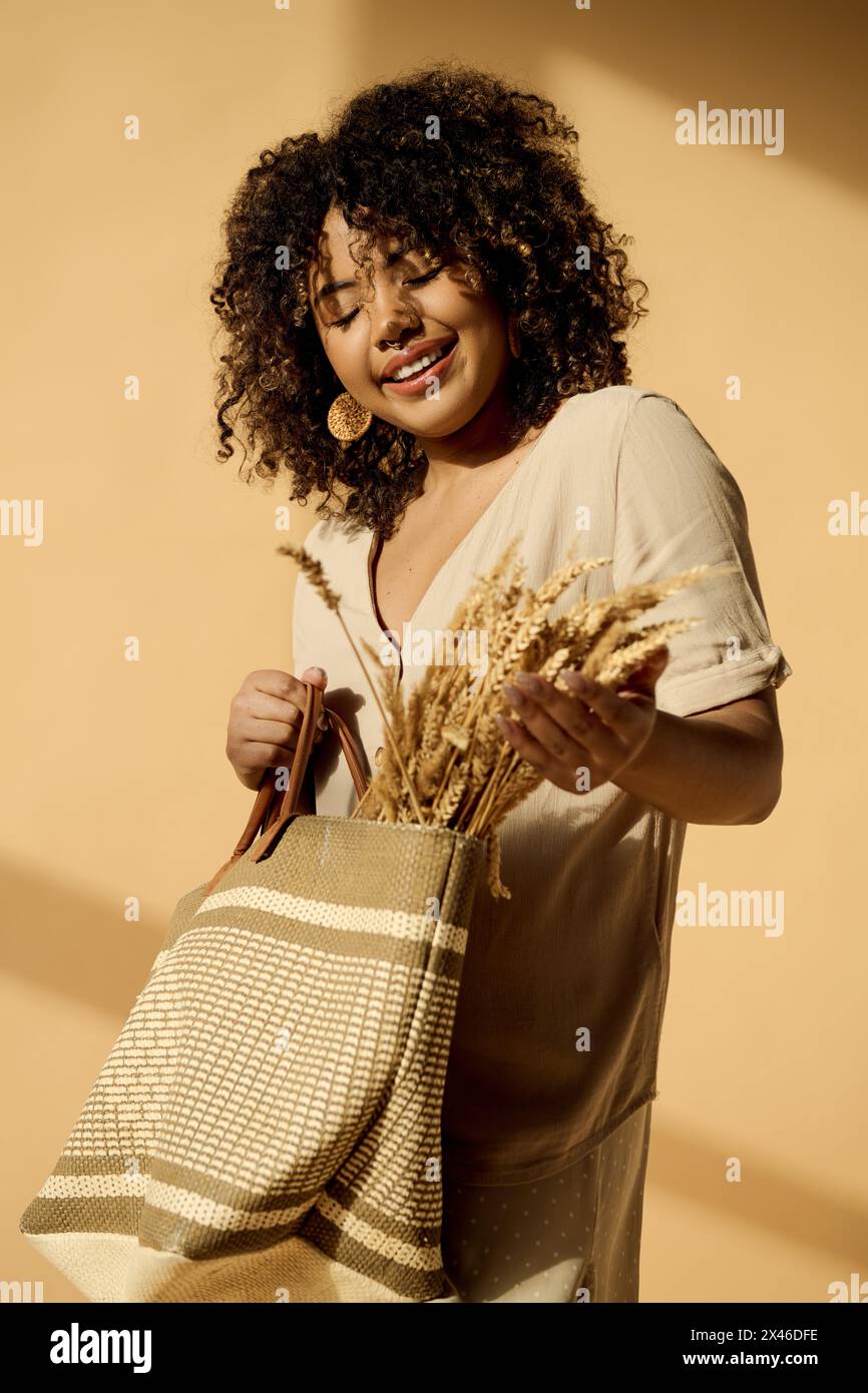 A beautiful young African American woman with curly hair holds a bag ...