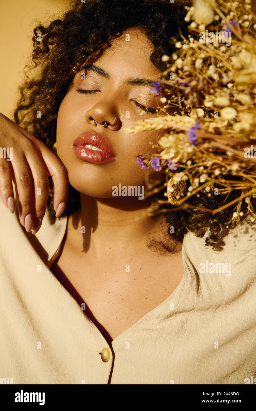 A beautiful African American woman with curly hair holding a vibrant ...