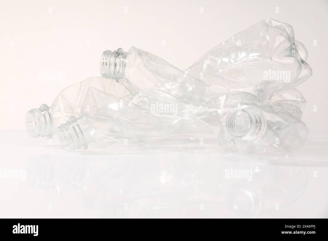 Crumpled disposable plastic bottles on white background Stock Photo - Alamy