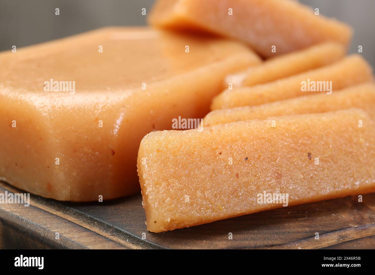 Tasty sweet quince paste on wooden board, closeup Stock Photo