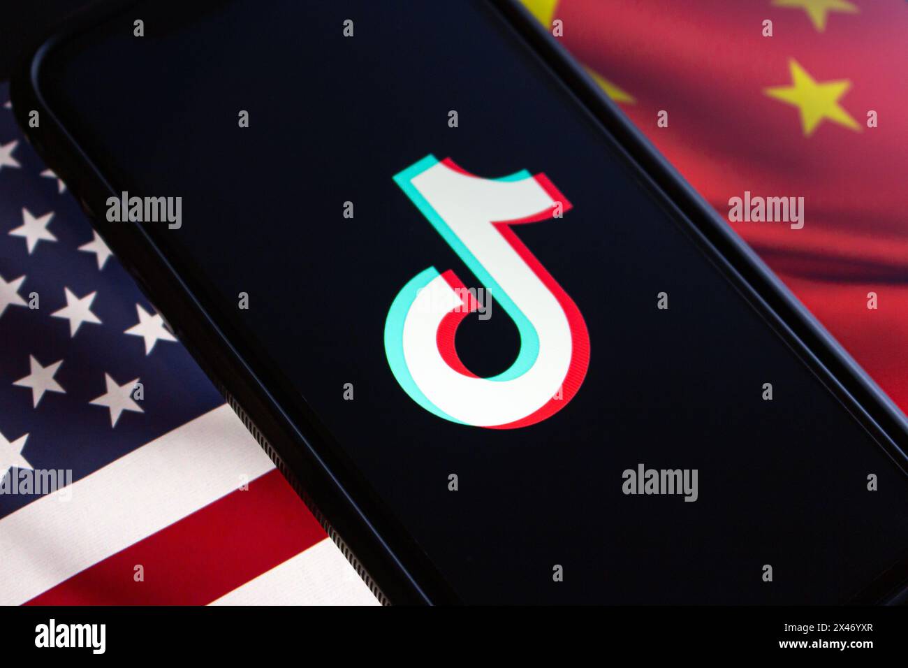 Vancouver, CANADA - Apr 30 2024 : TikTok logo seen in an iPhone screen on American flag and Chinese flag background Stock Photo