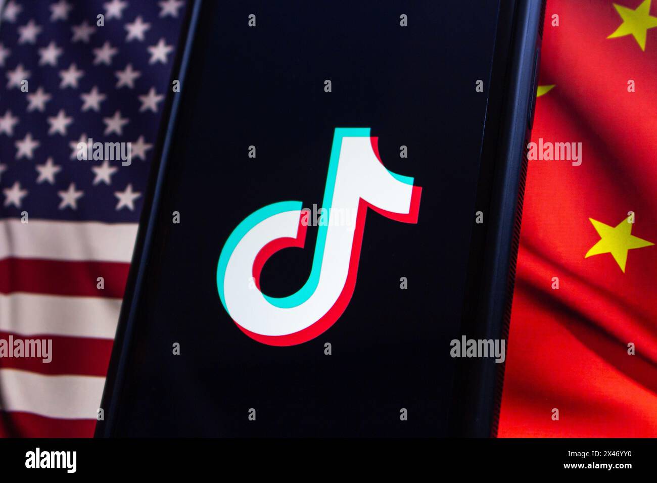 Vancouver, CANADA - Apr 30 2024 : TikTok logo seen in an iPhone screen on American flag and Chinese flag background Stock Photo