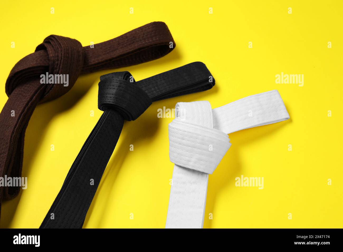 Colorful karate belts on yellow background, flat lay Stock Photo - Alamy