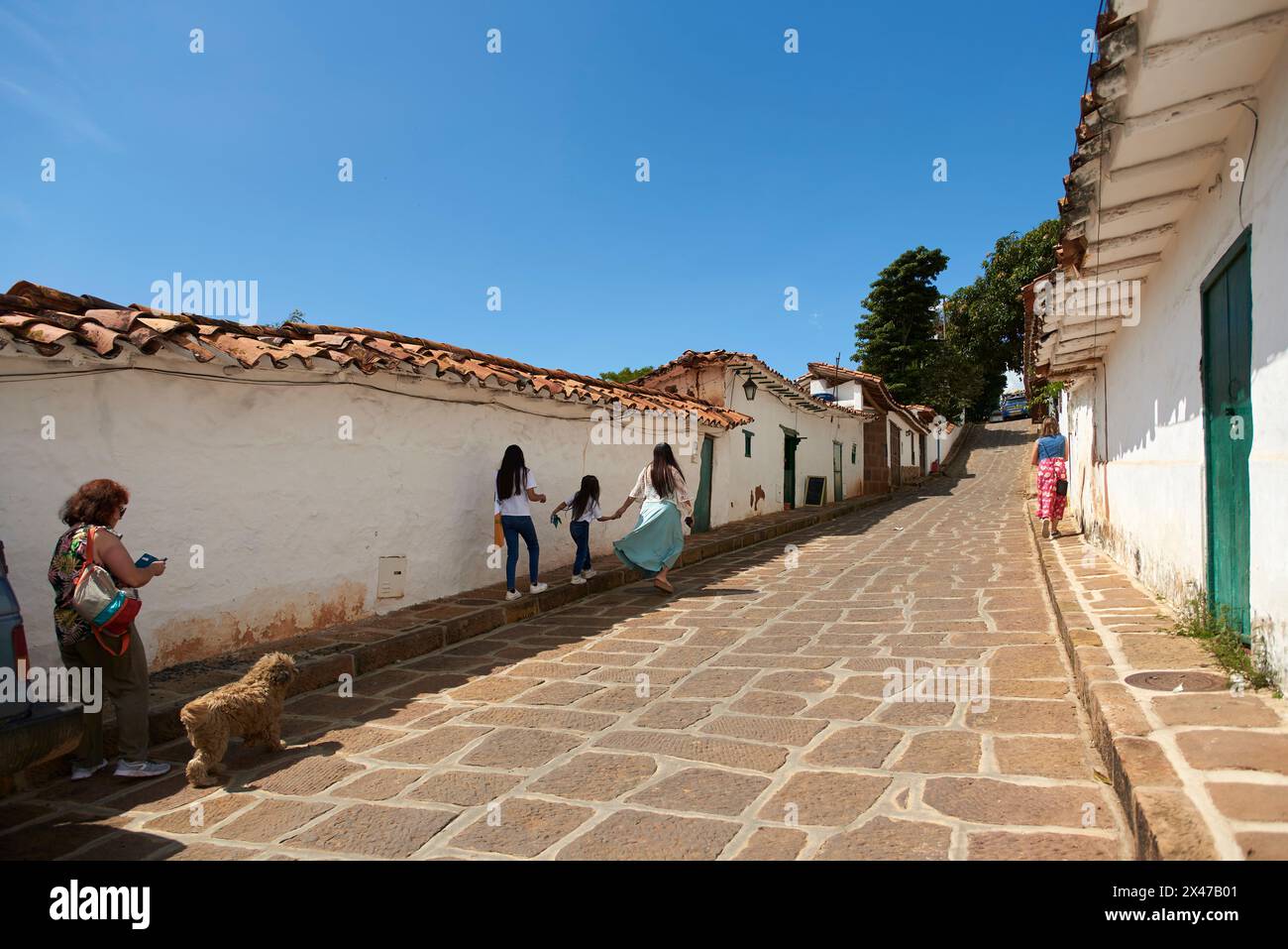 Barichara, Santander, Colombia; November 25, 2022: people walking along a street with colonial architecture in this tourist town, declared a National Stock Photo