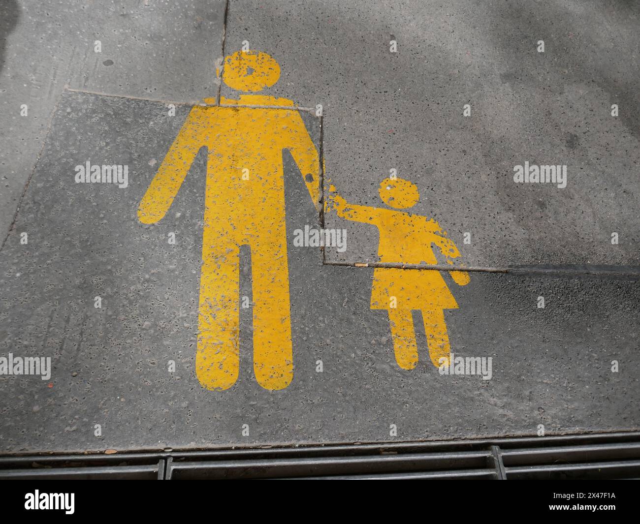 Pedestrian zone sign painted on road surface in Europe with parent holding child's hand Stock Photo