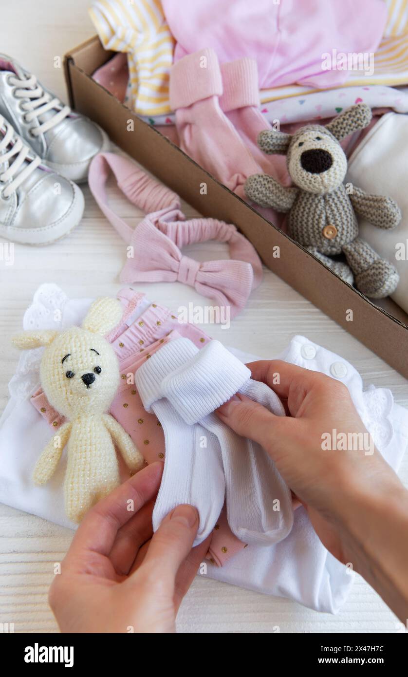 Women's hands collect children's clothes into boxes. The concept of ...
