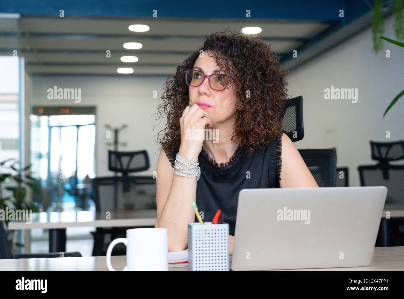 Woman thinking while working in an office Stock Photo - Alamy