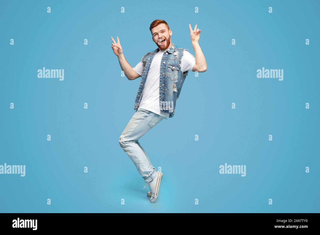 Awesome guy showing peace gesture and standing on tiptoes Stock Photo