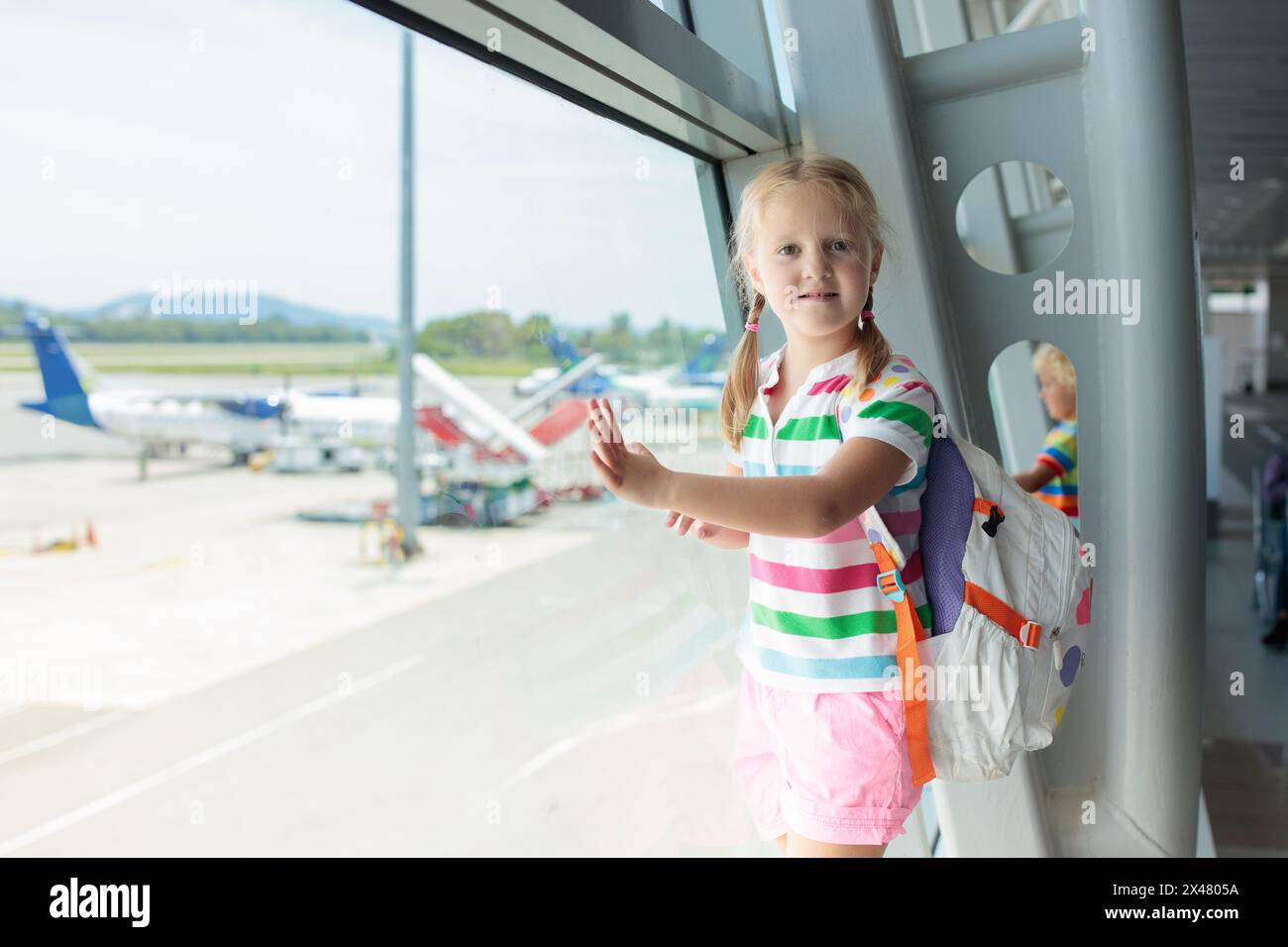Kids at airport. Children look at airplane. Traveling and flying with child. Family at departure gate. Vacation and travel with young kid. Stock Photo