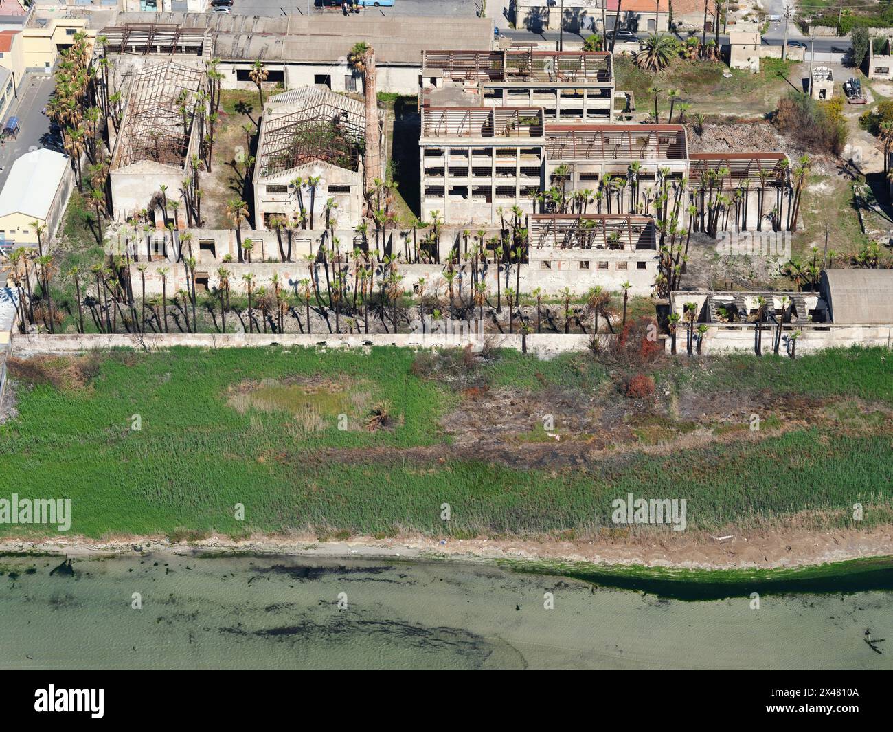 AERIAL VIEW. Abandoned buildings on the seafront in the city of Syracuse. Province of Syracuse, Sicily, Italy. Stock Photo