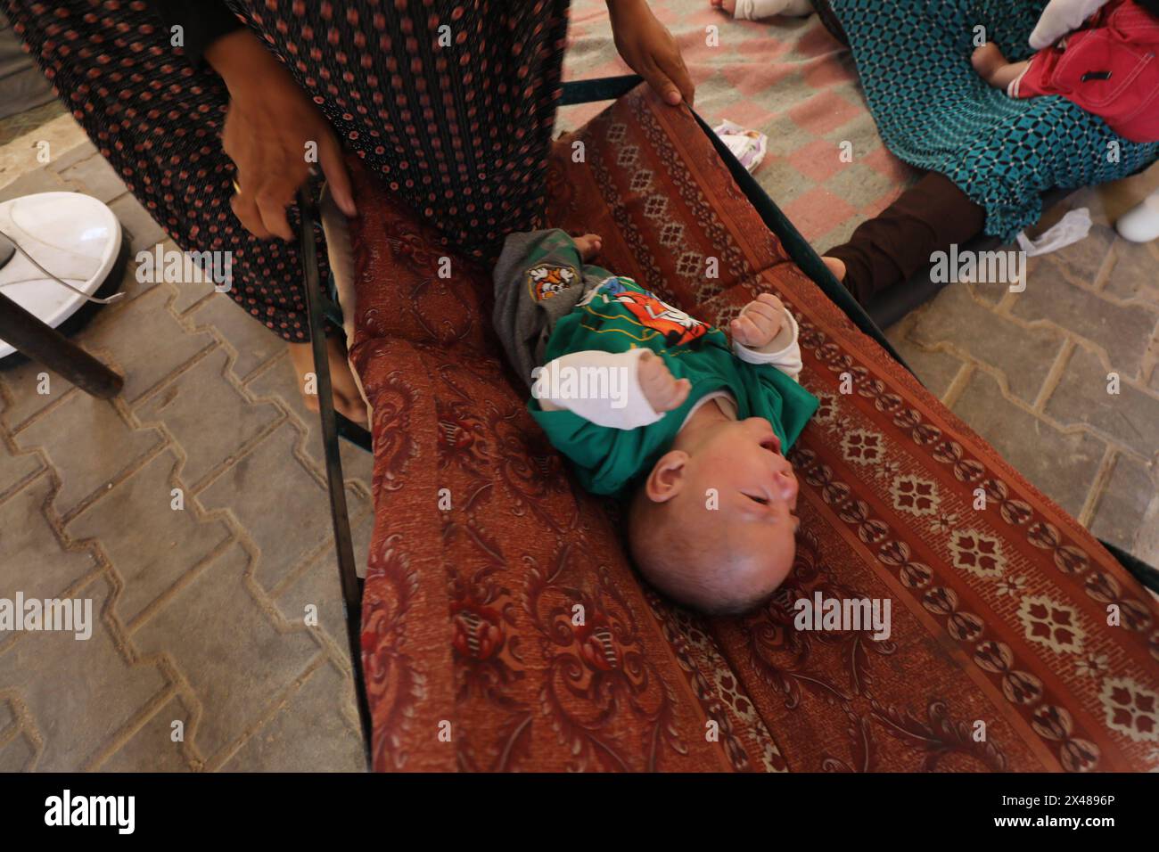 A Palestinian mother and her triplets shelter in their tent at a ...