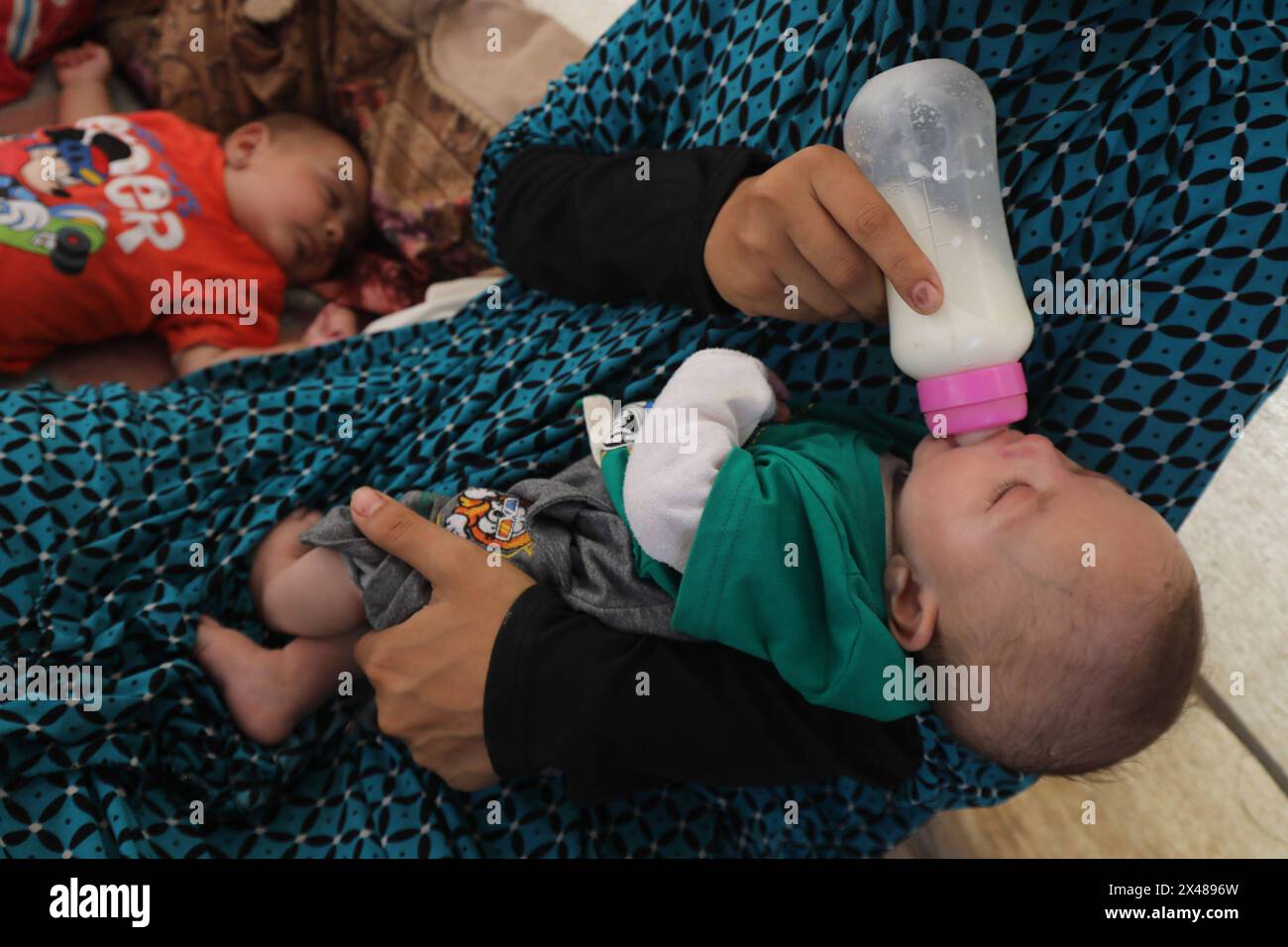 A Palestinian mother and her triplets shelter in their tent at a ...