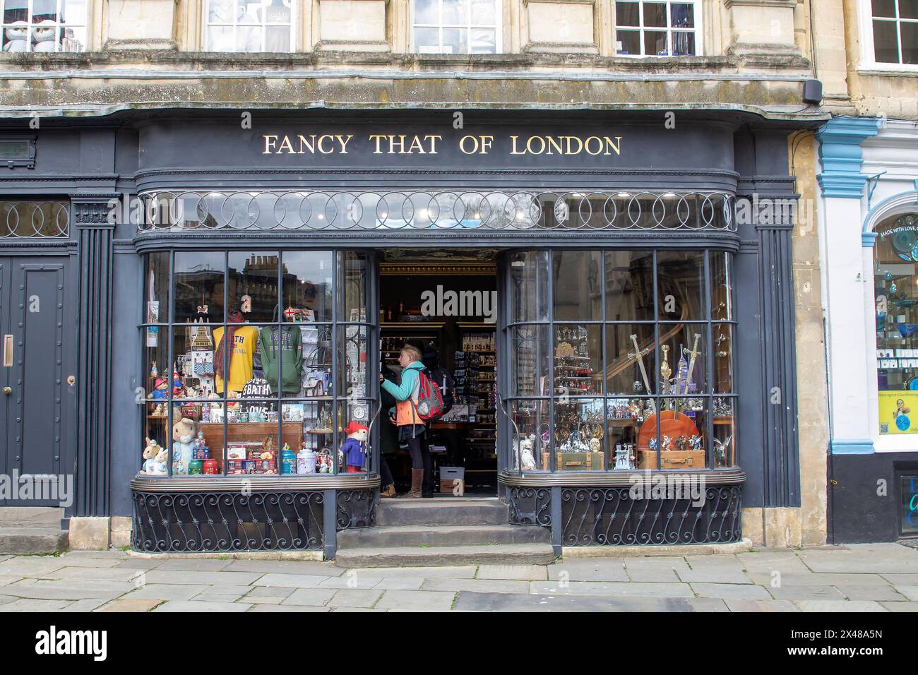 23 April 24 A customer browses in the retail business Fancy That of London souvenier shop in Abbey Church Yard Bath, Somerset  England on a fine sprin Stock Photo