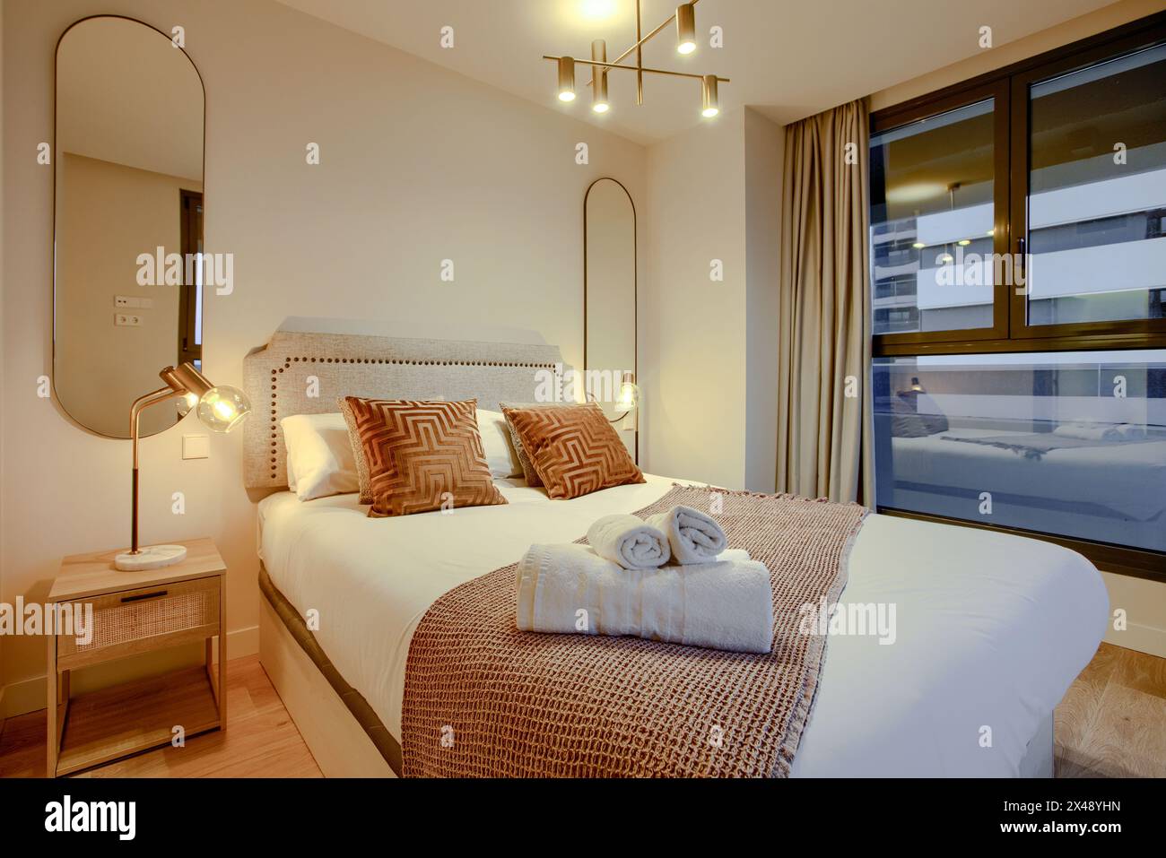Picture of A double bedroom with contemporary decoration, two mirrors on the wall ...
