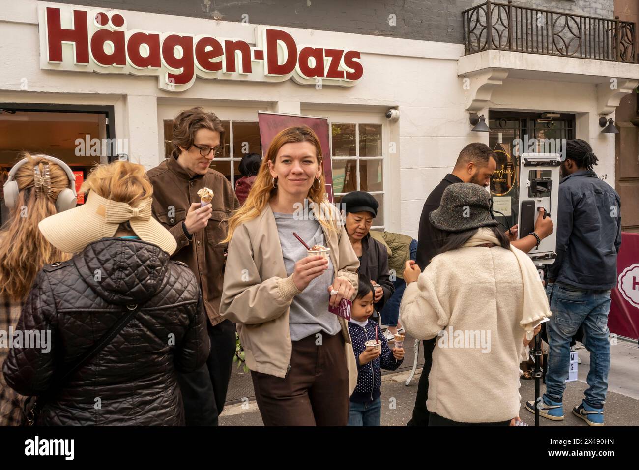 People line up for free scoops of HŠagen-Dazs ice cream celebrating the reopening of their store in Brooklyn Heights in New York on Saturday, April 27, 2024.The store is the first store opened by the ice cream company, in 1976. HŠagen-Dazs is a brand of General Mills. ( © Richard B. Levine) Stock Photo