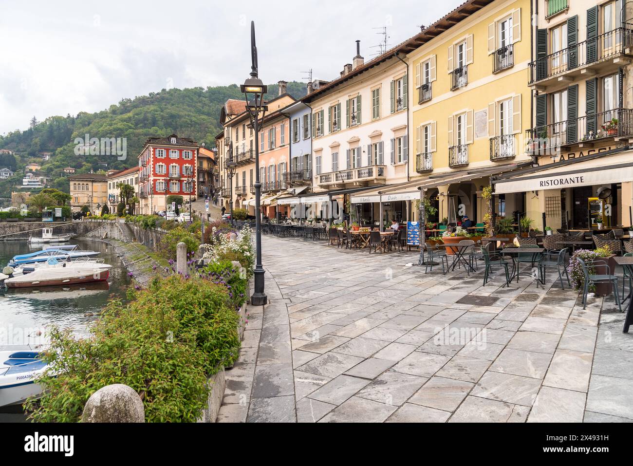 Cannobio, Piedmont, Italy - April 26, 2024: Lakefront of Cannobio with outdoor bars and restaurants, the popular holiday resort on the shore of Lake M Stock Photo