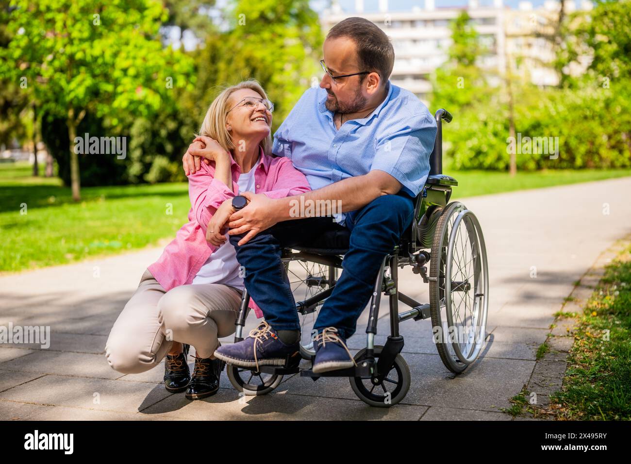 Man in wheelchair is spending time with his friend in park Stock Photo ...