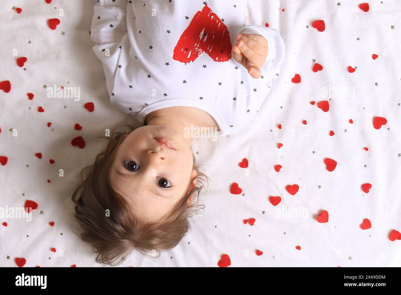 A baby with lots of red hearts surrounding him on white. Stock Photo