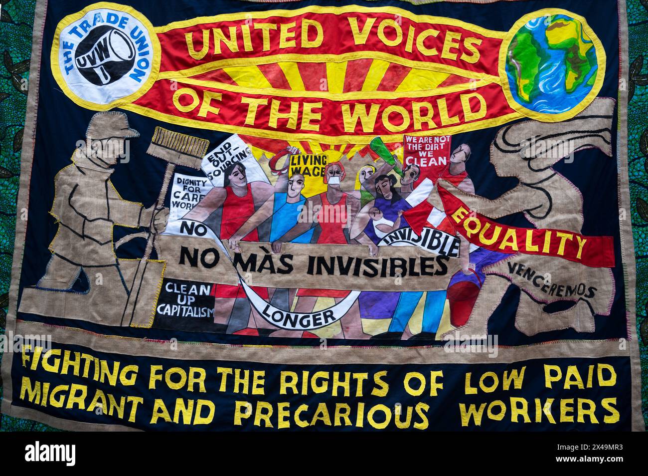 May 1st 2024. People assemble on Clerkenwell Green to march to Trafalgar Square to celebrate May Day. Handsewn banner of United Voices of the World; Stock Photo