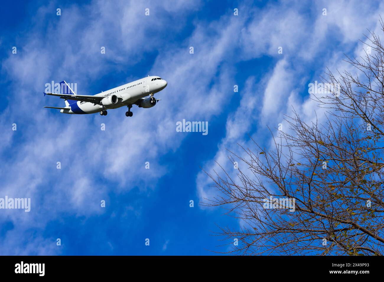 A passenger plane is flying in a beautiful blue sky with white clouds ...