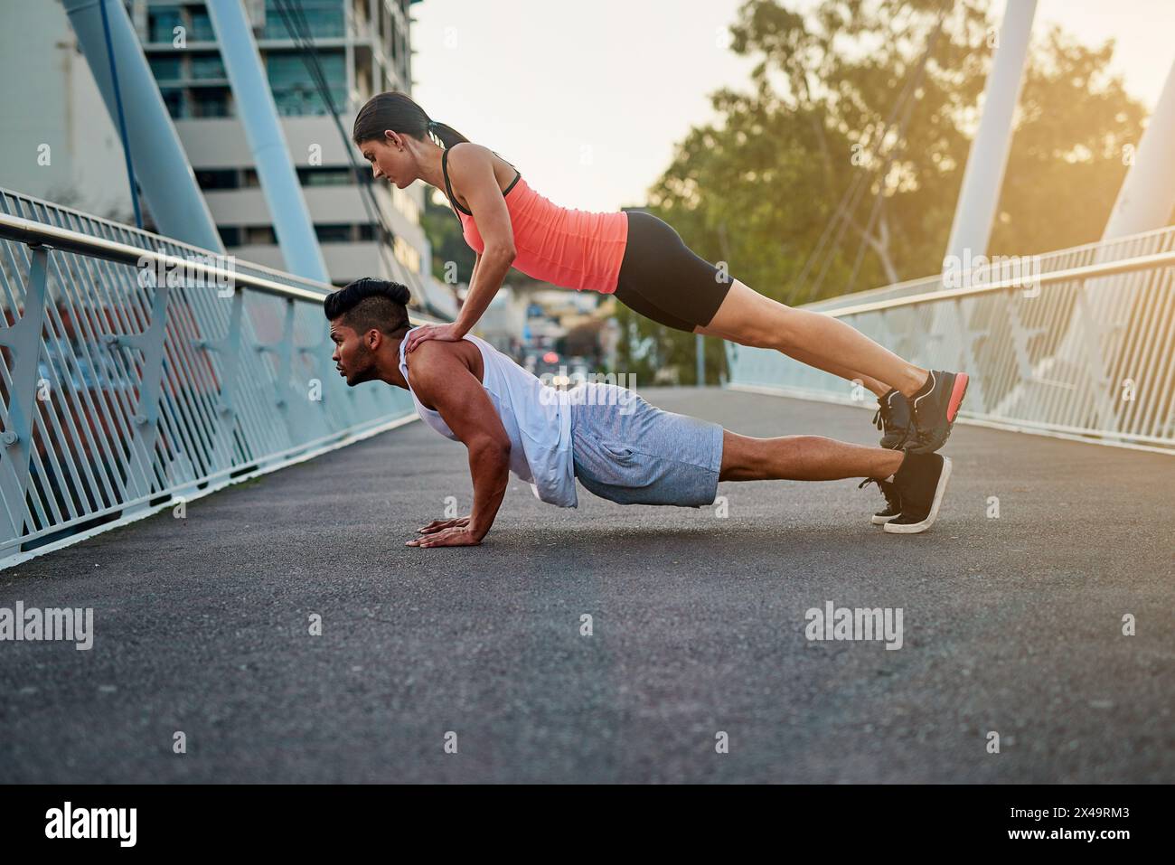 Couple, bridge and balance on back for fitness or daily exercise for training, pushup and workout partner for health. Man, girl and together outdoor Stock Photo