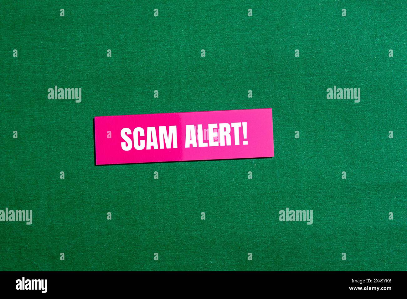 Scam alert words written on pink paper sticker with green background. Conceptual scam alert symbol. Copy space. Stock Photo