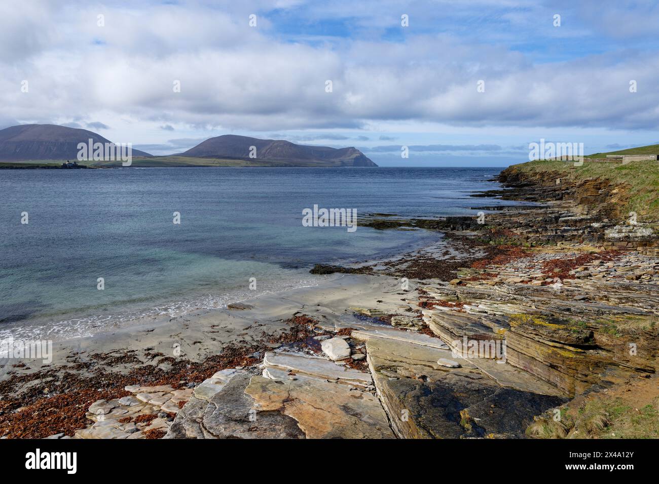 View from Stromness looking out over Hoy Sound shows the lighthouse on Graemsay on the left on onwards to the magnificent hills on the island of Hoy. Stock Photo