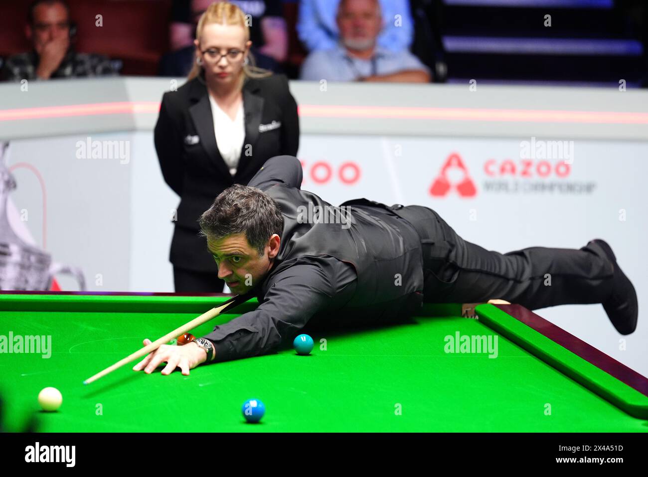 Ronnie O'Sullivan in action against Stuart Bingham (not pictured) as referee Desislava Bozhilova (left) looks on in the quarter-finals match on day twelve of the 2024 Cazoo World Snooker Championship at the Crucible Theatre, Sheffield. Picture date: Wednesday May 1, 2024. Stock Photo