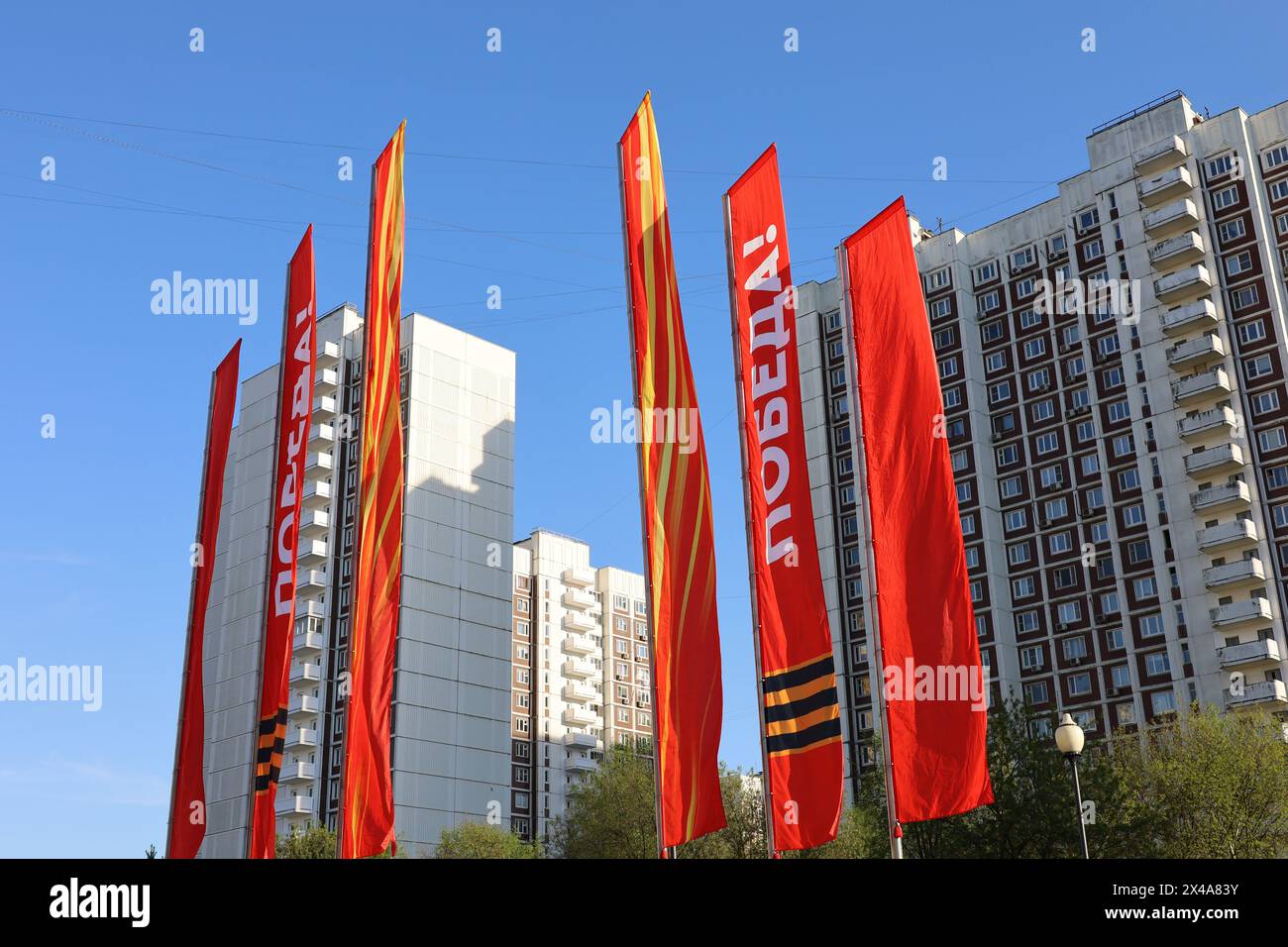 Red flags against the city buildings, Victory Day celebration in Russia Stock Photo