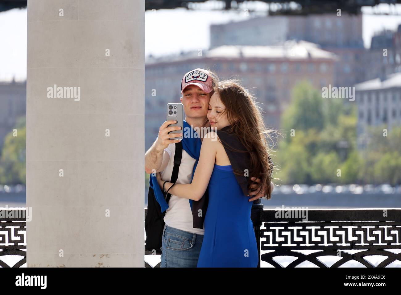 Young couple embracing and making selfie on a city embankment Stock Photo