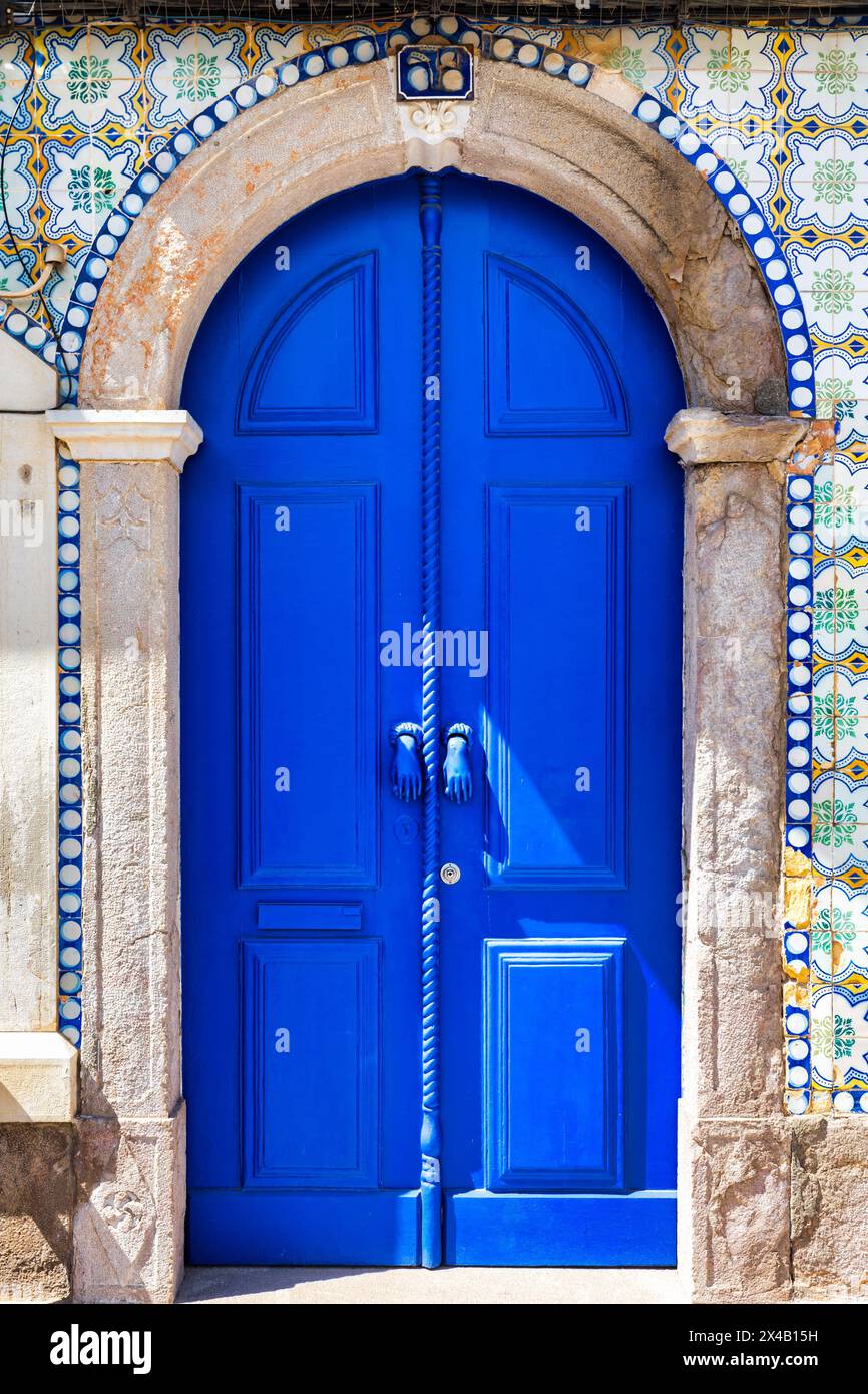 A blue door with a rope hanging from it, Tavira, Algarve, Portugal. Stock Photo