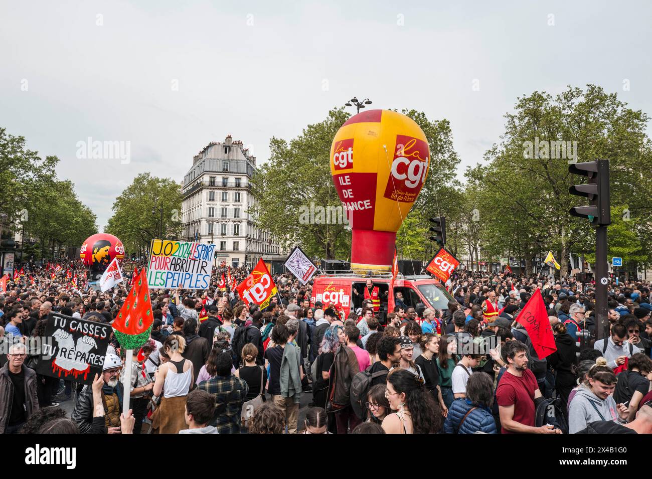 Arrival at Bastille. The balloon CGT Ile de France, the placard of the artist Jean-Batiste Redde, J.O. 2024 le sport pour abrutir les peuples, in the crowd. May 1, 2024 demonstration in Paris against austerity, for jobs and wages. France, Patis on May 1, 2024. Photograph by Patricia Huchot-Boissier / Collectif DyF. Stock Photo