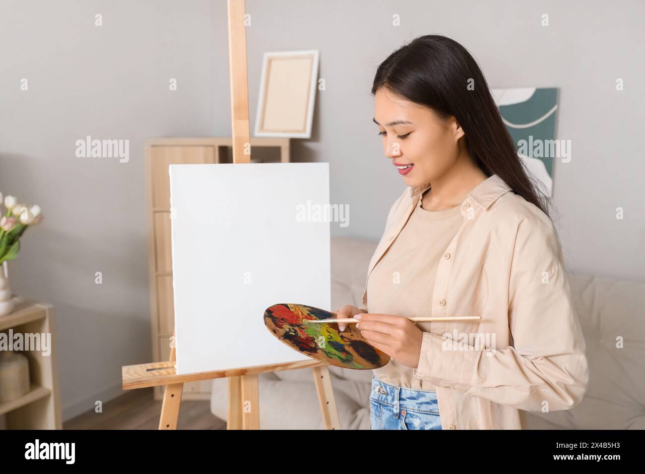 Female Asian artist with paint palette at home Stock Photo - Alamy