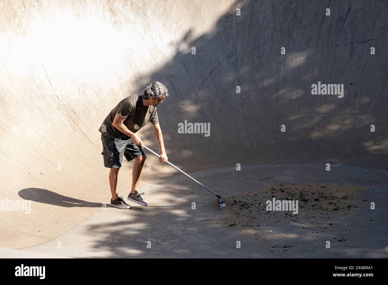 54 year old Brazilian sweeping the skate lane before using it 1. Stock Photo