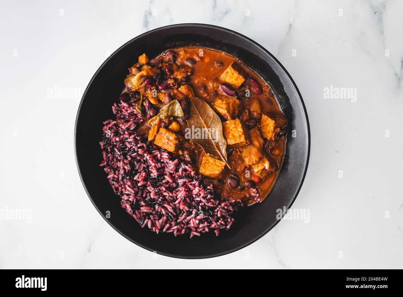 plant-based feijoada bean and tempeh stew with wild rice, healthy vegan food recipes Stock Photo