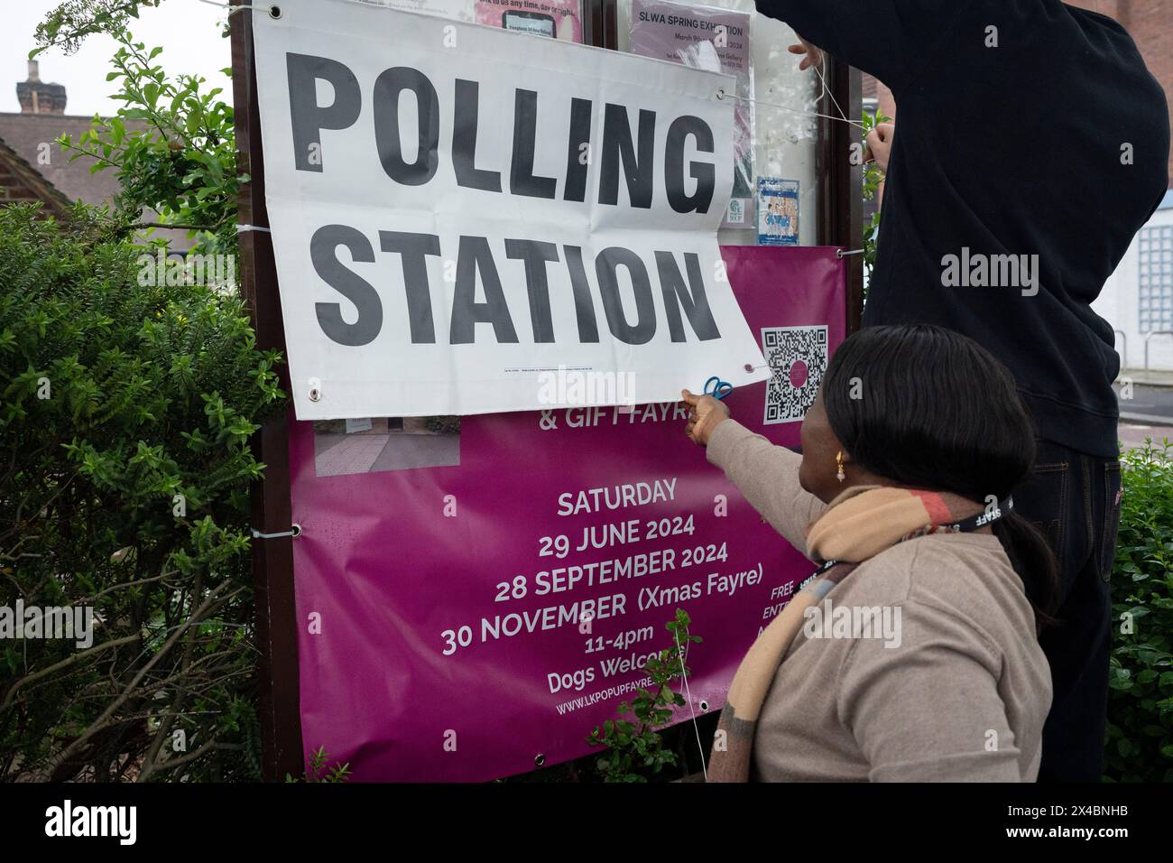 Polling station staff attach posters outside St Barnabas Parish Hall in Dulwich Village, on the day that Londoners vote for their mayor and London Assembly members, on 2nd May 2024, in London, England. Stock Photo