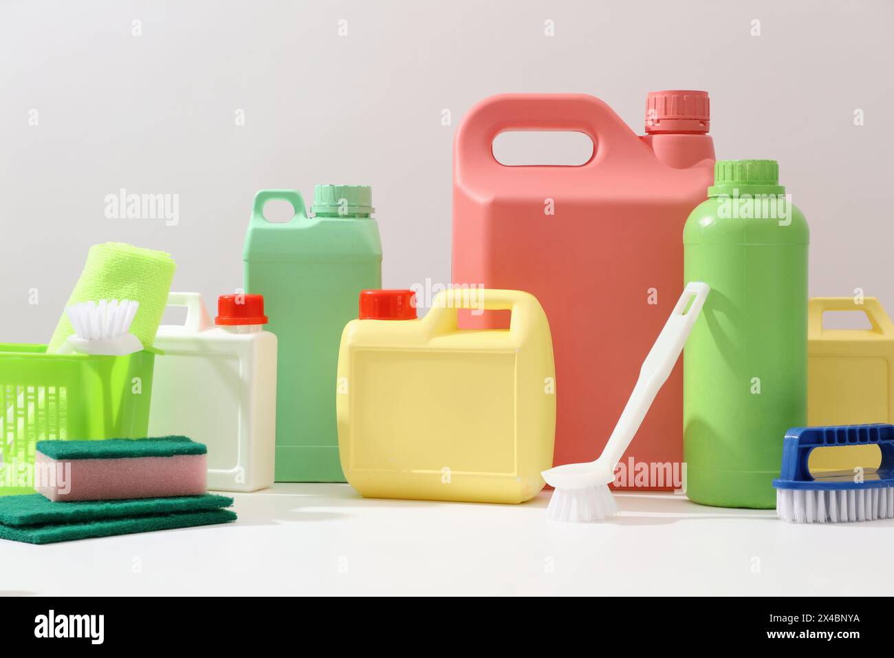Front view of different bottle and canisters mockup of detergent product displayed on white background with cleaning tools. Housework and professional Stock Photo