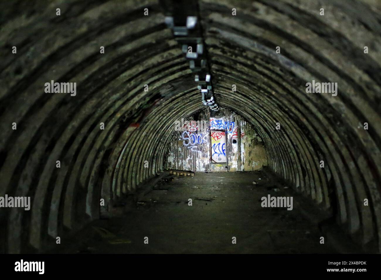 Abandoned tunnel bunker, partially illuminated by a flashlight. Stock Photo