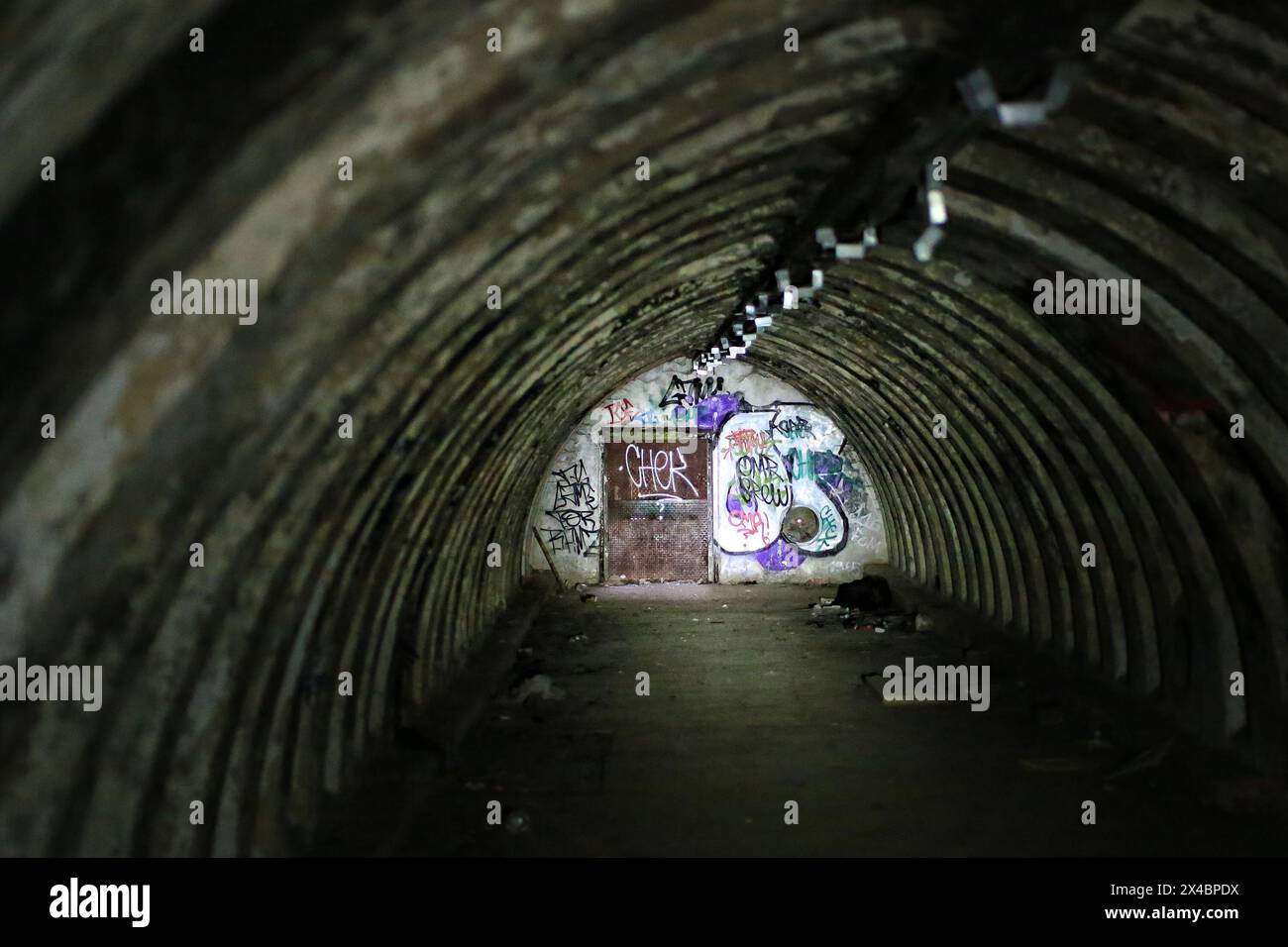 Abandoned tunnel bunker, partially illuminated by a flashlight. Stock Photo