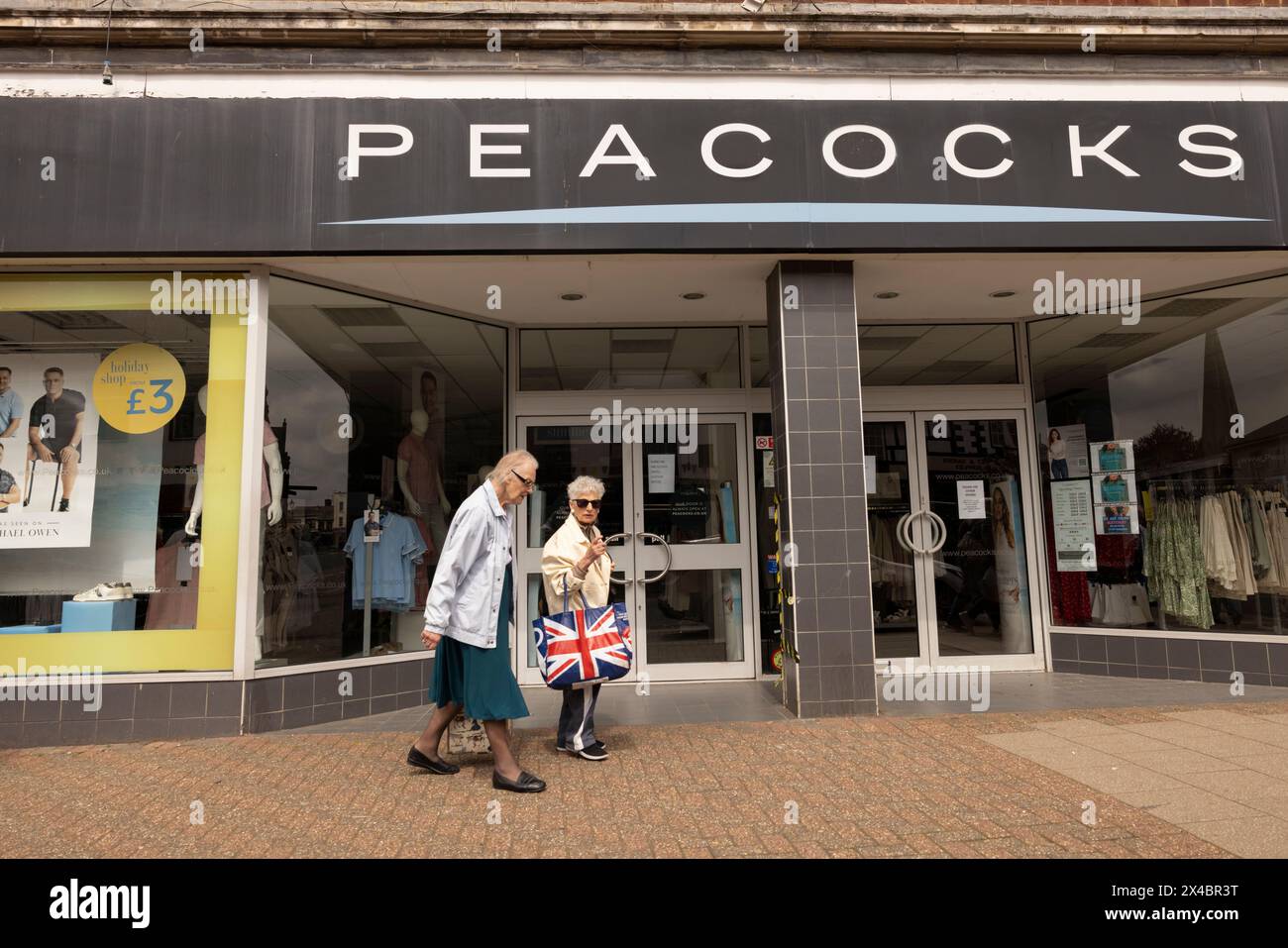 Two elderly ladies at the window display of PEACOCKS clothing chainstore in Leighton Buzzard, Bedfordshire, England, United Kingdom Stock Photo