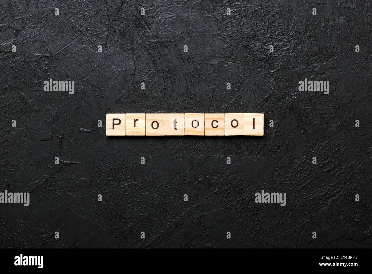 PROTOCOL word written on wood block. PROTOCOL text on cement table for ...